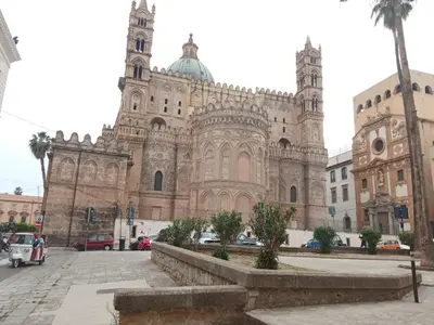 a large building with a cathedral with a palm tree in front at ZU' NICOLA in Palermo