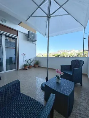 a patio with a table and chairs and an umbrella at Casa Indipendenza - Cattedrale in Palermo