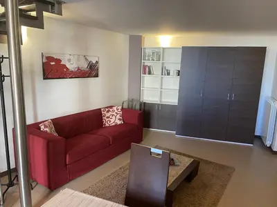 a living room with a red couch and a table at Marconi e Garibaldi 76 apartment in Castellammare del Golfo