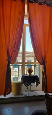 a window with orange curtains and a table in front of it at BALLARHOUSE in Palermo