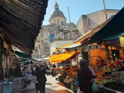 a group of people walking through an outdoor market at BALLARHOUSE in Palermo
