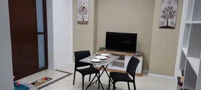 a room with a table with chairs and a television at Leam Apartment 5 in Palermo
