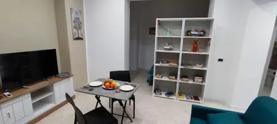a living room with a table and a television at Leam Apartment 5 in Palermo