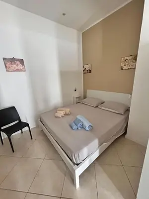 a bedroom with a bed and a chair in it at Leam Apartment 5 in Palermo