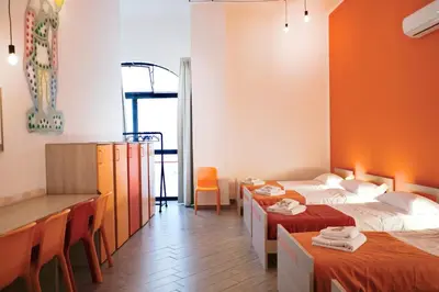 a room with two beds and a table and chairs at Cortile dei Giusti - Combo Guesthouse in Palermo