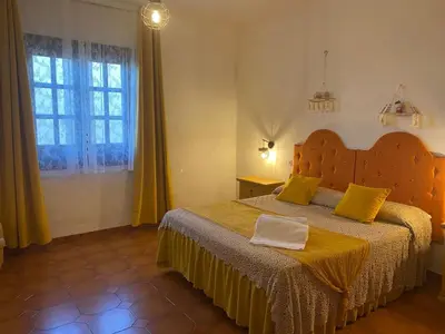 a bedroom with a bed with yellow pillows and a window at Villa Contrada Sauci in San Vito lo Capo