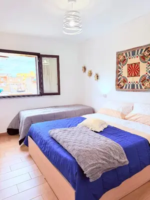a bedroom with two beds and a window at Casa vacanza CUTÓ in Bagheria