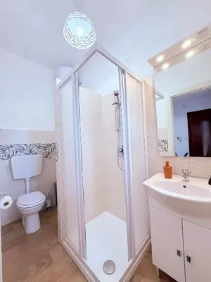a bathroom with a shower and a toilet and a sink at Casa vacanza CUTÓ in Bagheria