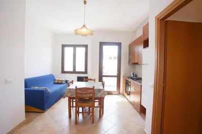 a living room with a blue couch and a table at SanVitoTour- Appartamento Smeraldo in San Vito lo Capo