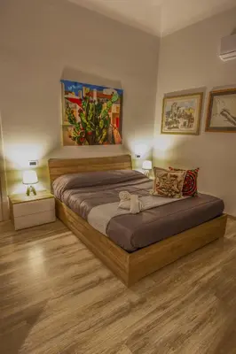 a bedroom with a large wooden bed and two lamps at Quintino 57 Al Politeama - Tourist Lease in Palermo