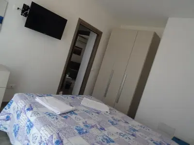 a bedroom with a bed and a tv and a mirror at Casa Diamante in San Vito lo Capo