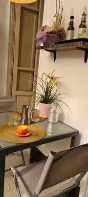 a table with two chairs and a table with flowers at Appartamento centro in Palermo
