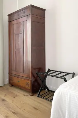 a wooden cabinet in the corner of a bedroom at Dimora Borghese “Florio” in Palermo