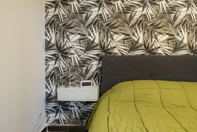 a bedroom with a yellow bed and a wall at 4 Canti Central cozy apt in via Maqueda in Palermo