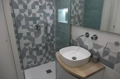 a bathroom with a white sink and a shower at Opera Suites - Norma in Palermo