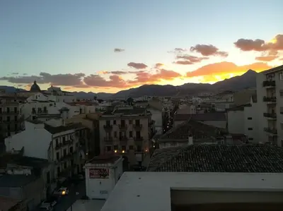 a view of a city at sunset with buildings at A terrace in the heart of Palermo in Palermo