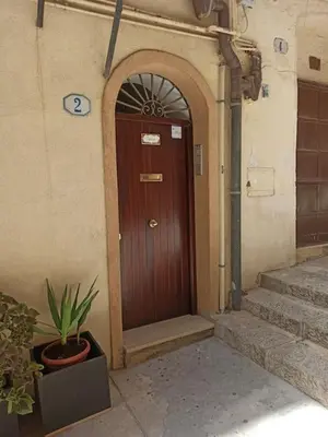 a wooden door in a building with a potted plant at A terrace in the heart of Palermo in Palermo