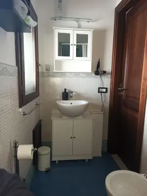 a bathroom with a white sink and a mirror at A terrace in the heart of Palermo in Palermo