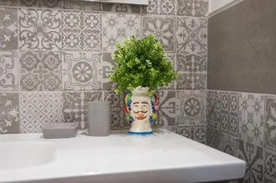 a vase with a plant on top of a sink at Mille91 Apartment in Palermo