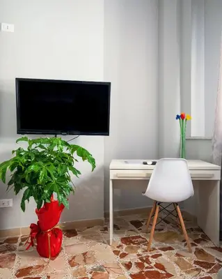 a room with a desk and a tv and a plant at Mille91 Apartment in Palermo