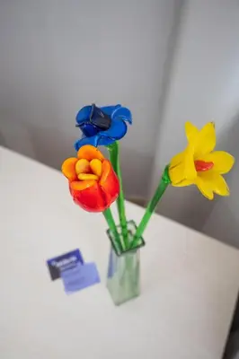 three fake flowers in a vase on a table at Mille91 Apartment in Palermo