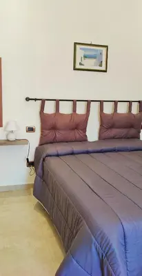 a bedroom with a large bed with purple sheets at Il Principe casa vacanze in Trabia