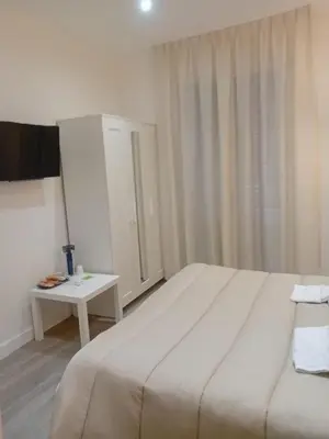 a bedroom with a large white bed and a table at ABT L'AURA in Palermo