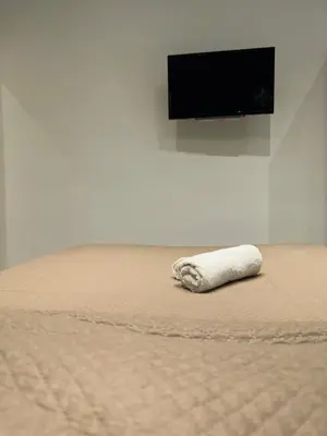 a white towel laying on a bed in a room at ABT L'AURA in Palermo