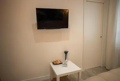 a room with a table with a tv on the wall at ABT L'AURA in Palermo