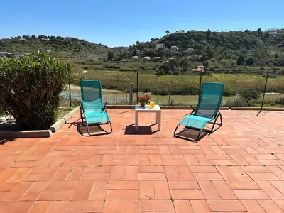 two blue chairs and a table on a brick patio at Villa FIORENZA in Castellammare del Golfo