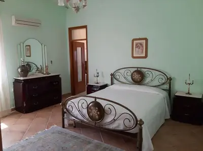 a bedroom with a bed and two dressers and a mirror at casa di Enrico in Palermo