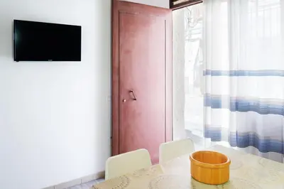 a dining room with a table and a red door at Meg Sicily House in Castellammare del Golfo