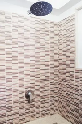 a bathroom with a shower with wooden tiles at Meg Sicily House in Castellammare del Golfo