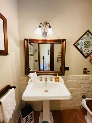 a bathroom with a sink and a mirror at Villa Inserra Deluxe in Palermo