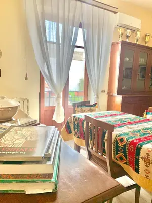 a room with two beds and a table and a window at Daziarosetta in Palermo