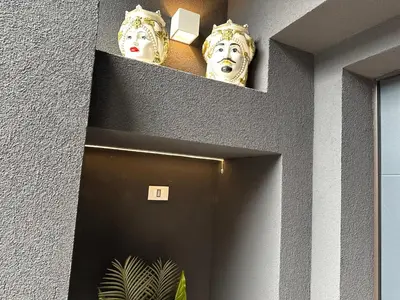 a hallway with two masks above a door at Flat with Jacuzzi - Casa Pia in Mondello