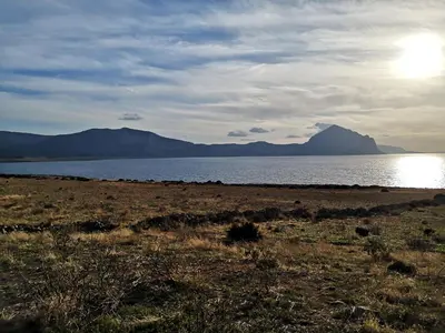 a large body of water with a mountain in the background at APPARTAMENTO A SAN VITO LO CAPO STANZA CON BAGNO in San Vito lo Capo