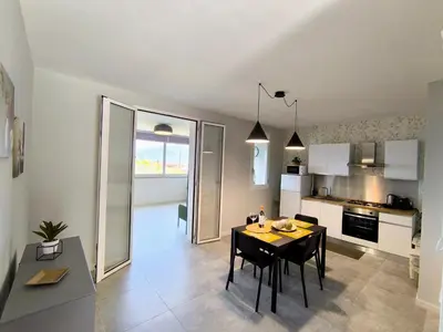 a kitchen and dining room with a table and chairs at Piante del Principe Apartments in Carini