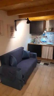 a living room with a blue couch and a kitchen at Casa vacanza Gio in Palermo