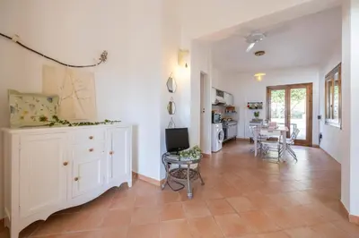 a kitchen and living room with a table and chairs at Pittalumari Makari in Macari