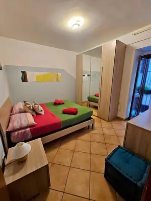 a bedroom with a bed with red and green sheets at Happie Casa Il Capo & La Cattedrale in Palermo
