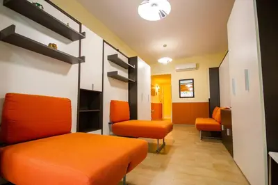a waiting room with orange furniture and orange chairs at M'Place - Mondello Residence in Palermo