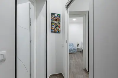 a hallway with a mirror and a painting on the wall at GuestHost - La Casa di Martina - Palermo Central Apartments in Palermo