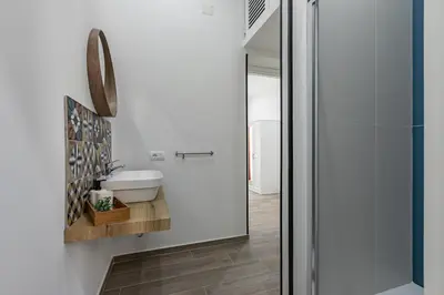 a white bathroom with a sink and a mirror at GuestHost - La Casa di Martina - Palermo Central Apartments in Palermo