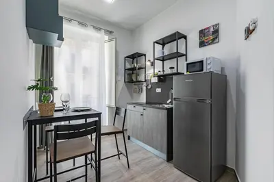 a small kitchen with a table and a refrigerator at GuestHost - La Casa di Martina - Palermo Central Apartments in Palermo