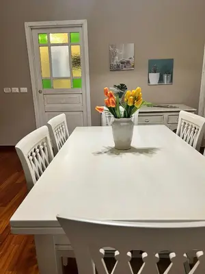 a white kitchen table with a vase of flowers on it at MeliKris home in Palermo