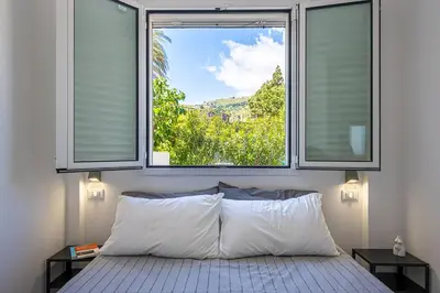 a bedroom with two windows and a bed with white pillows at Federica's House - Sporting Village in Scopello