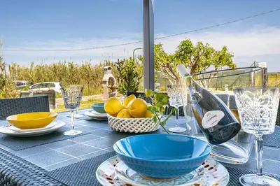 a table with plates and bowls and glasses on it at Federica's House - Sporting Village in Scopello