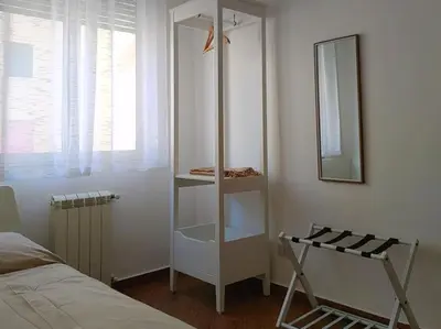 a white shelf in a bedroom with a mirror at Appartamento Ai Murales in Palermo