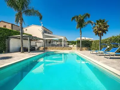 a house with a swimming pool and palm trees at Villa Dell'Ulivo con piscina privata By Sicily Home Solutions in Alcamo